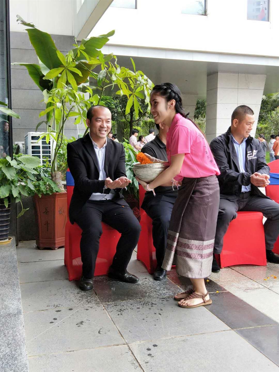 老撾駐廣西留學(xué)生代表將浸有花瓣的香水灑客人的手上，表示對嘉賓的美好祝福（圖一）