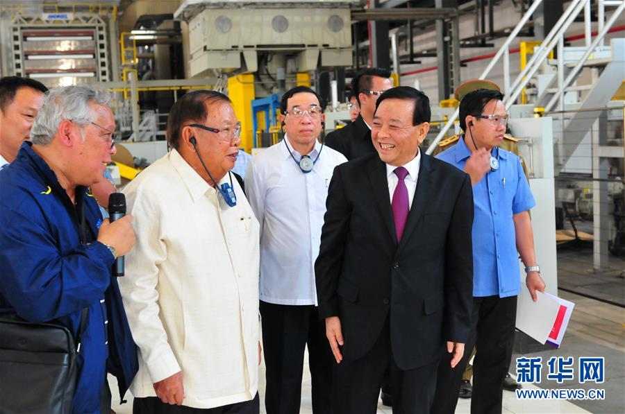 3月10日，在老撾沙灣拿吉省車邦縣，老撾人民革命黨中央總書記、國(guó)家主席本揚(yáng)（左二）在山東太陽(yáng)紙業(yè)股份有限公司董事長(zhǎng)李洪信（右二）的陪同下視察公司。 新華社記者章建華攝